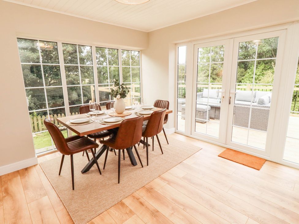 A dining room with a table set for a meal at Hedley Dene Cottage in Longhorsley