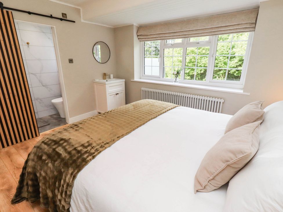 A bedroom with a bed and window at Hedley Dene Cottage in Longhorsley