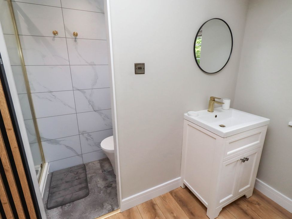 A bathroom with a shower, toilet, and sink at Hedley Dene Cottage Longhorsley