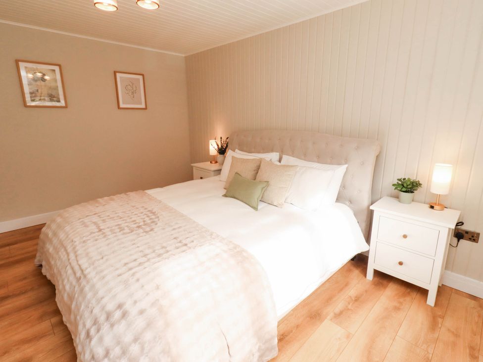 A bedroom with a bed and nightstand at Hedley Dene Cottage Longhorsley