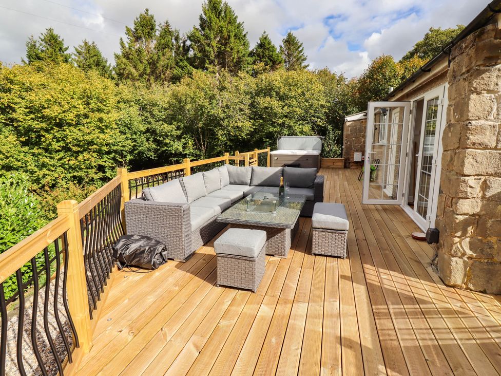 An outdoor seating area with a sofa and coffee table at Hedley Dene Cottage Longhorsley