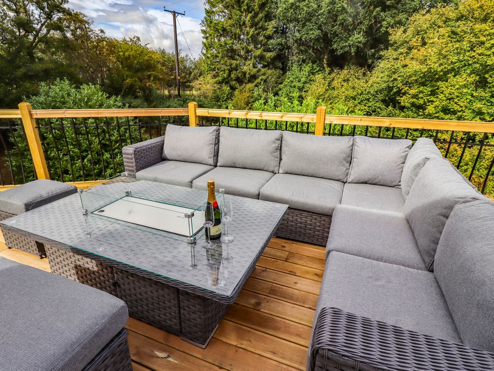 An outdoor seating area with a sofa and a coffee table at Hedley Dene Cottage Longhorsley