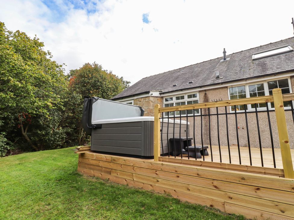 An outdoor area with a hot tub and deck at Hedley Dene Cottage in Longhorsley