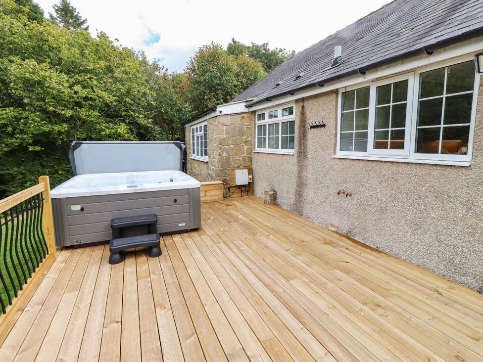 An outdoor deck with a hot tub at Hedley Dene Cottage in Longhorsley