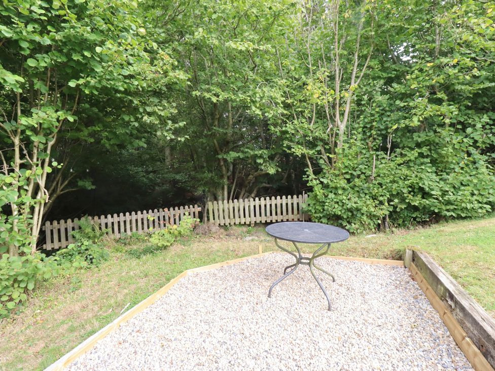 A garden with a table and gravel at Hedley Dene Cottage Longhorsley