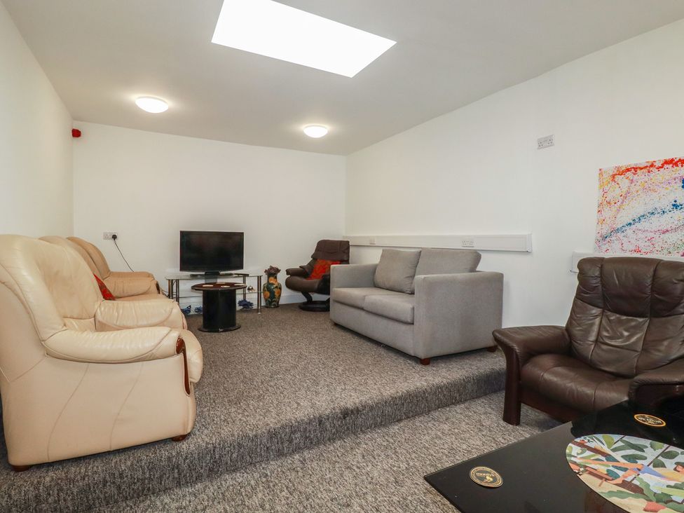 A living room with a television and seating at Newseal House