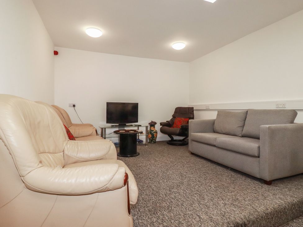 A living room with a sofa and television at Newseal House