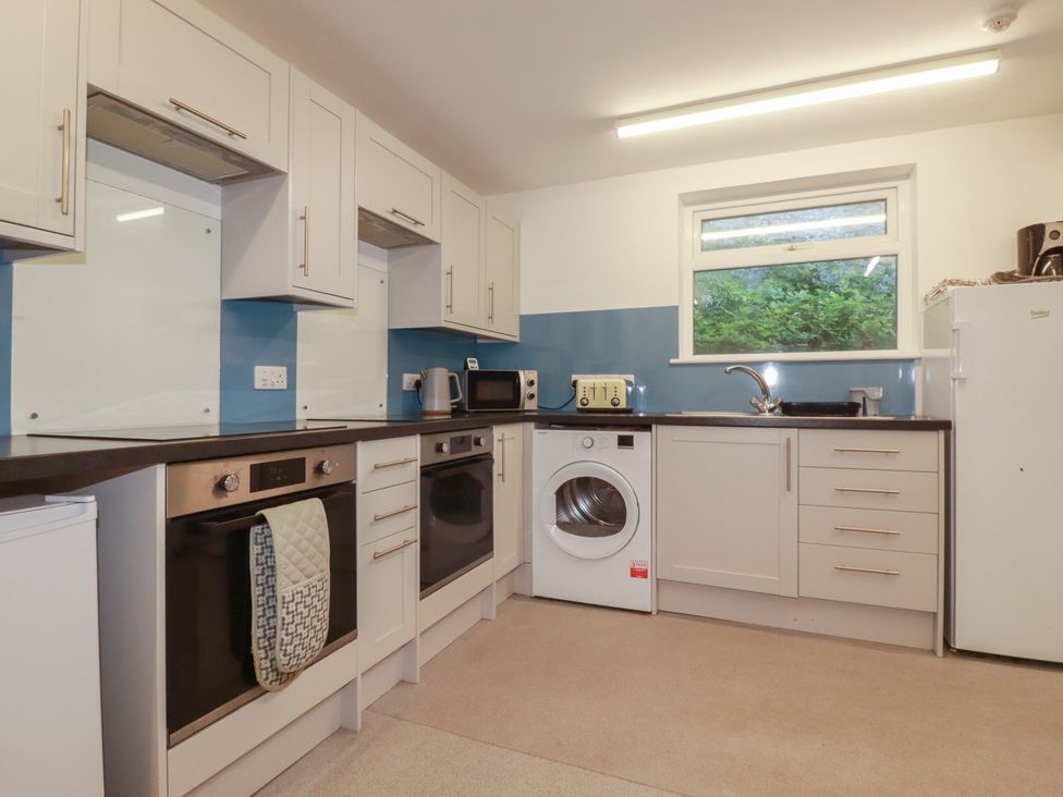 A kitchen with appliances and a window at Newseal House