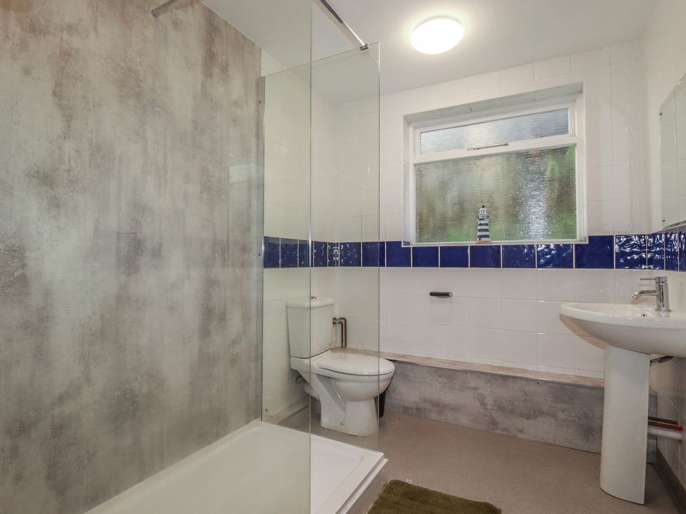 A bathroom with a shower, toilet, and sink at Newseal House 