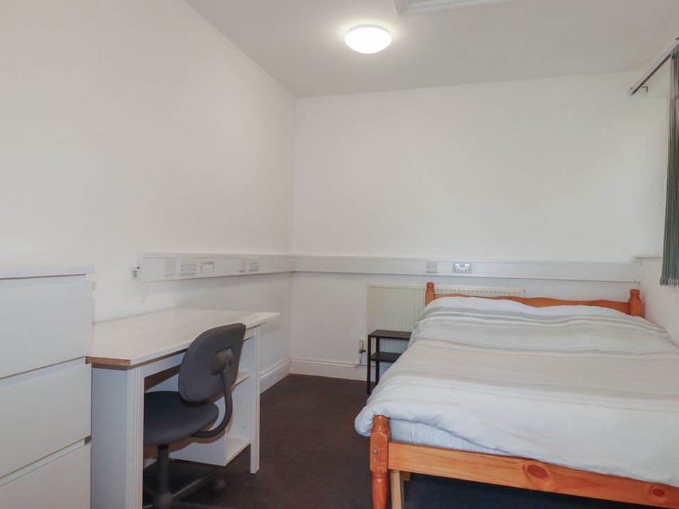 A bedroom with a bed, desk and chair at Newseal House