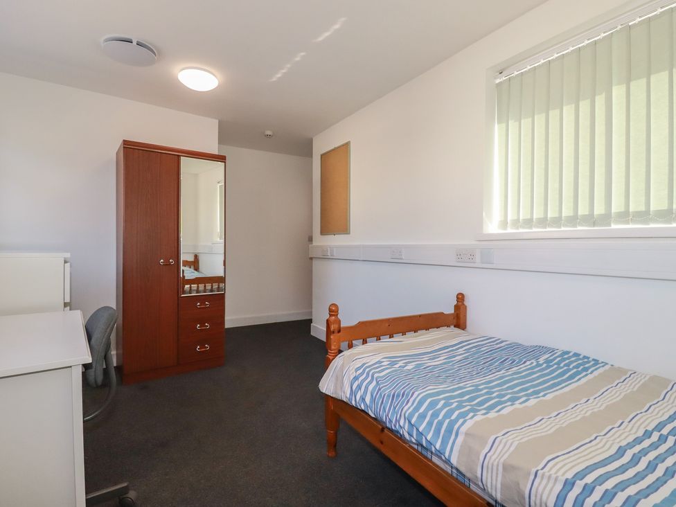 A bedroom with a bed and wardrobe at Newseal House