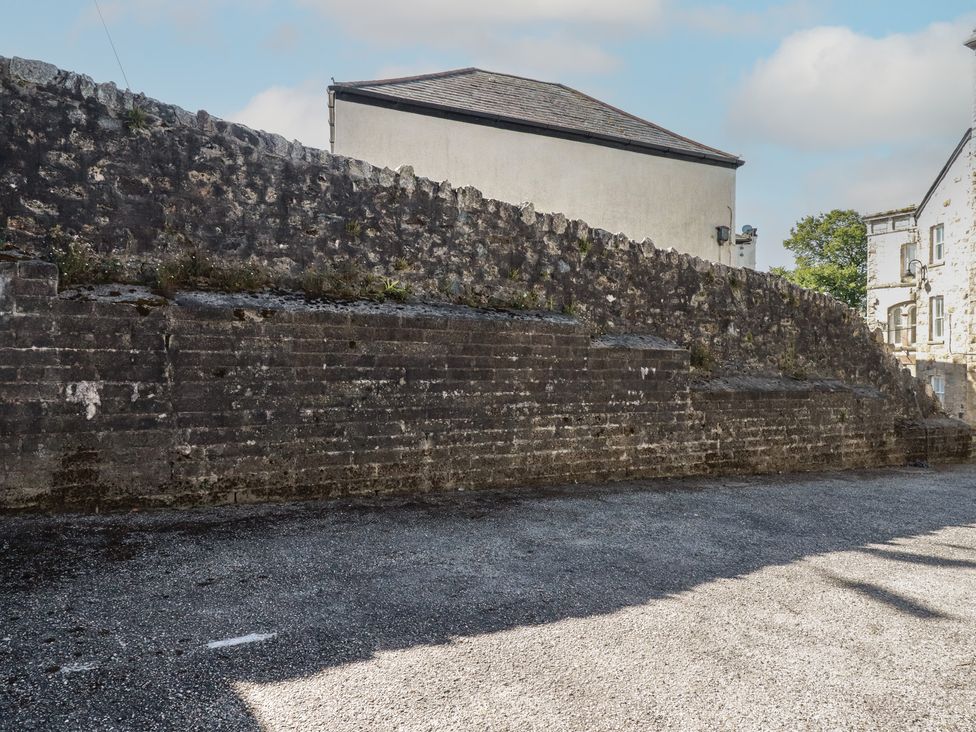An outdoor area with a stone wall and gravel surface at Newseal House