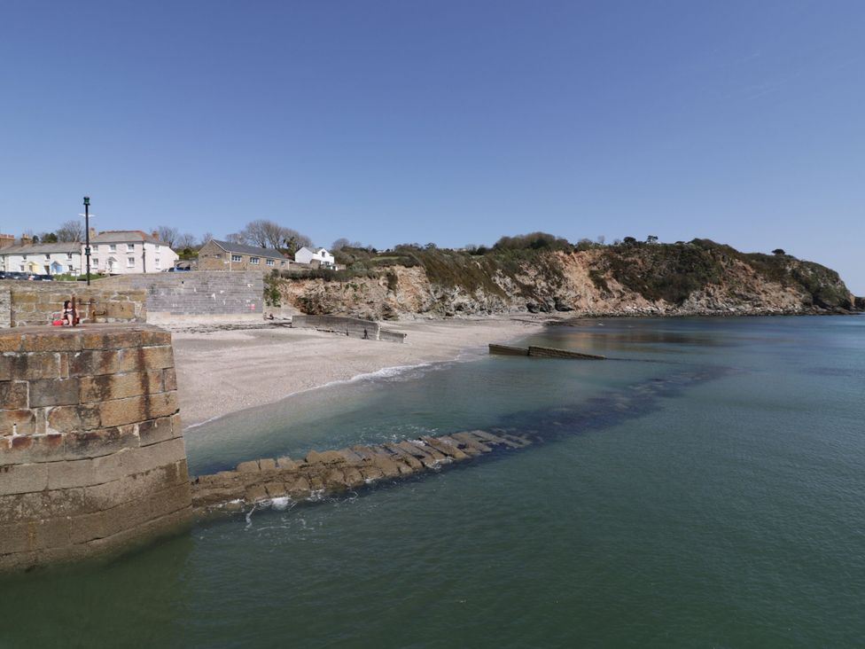 A beach with water and cliffs at Newseal House St Austell