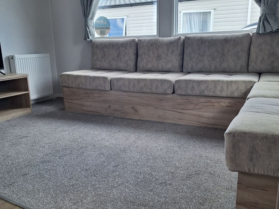 A living room with a sofa and television at Haven Seashore, Ellerton Willerby Xtra in Great Yarmouth