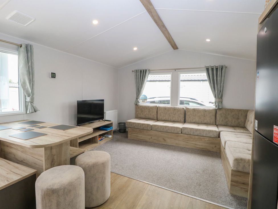 A living room with a sofa and television at Haven Seashore, Ellerton Willerby Xtra in Great Yarmouth