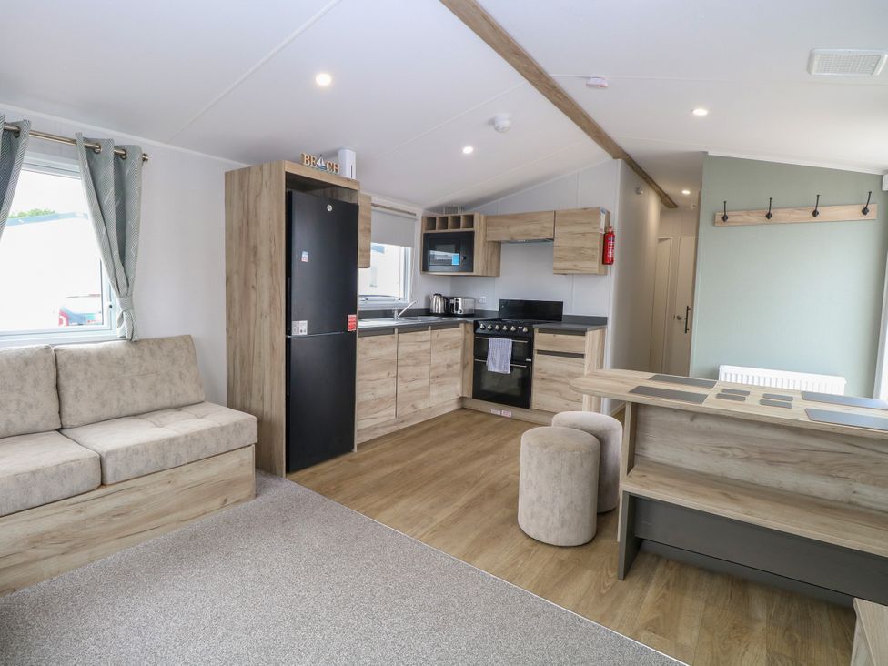 A kitchen with appliances and seating at Haven Seashore, Ellerton Willerby Xtra, Great Yarmouth