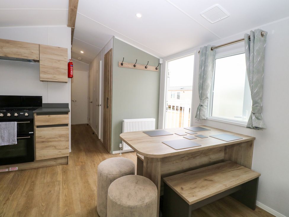 A kitchen with dining area and stove at Haven Seashore, Ellerton Willerby Xtra in Great Yarmouth