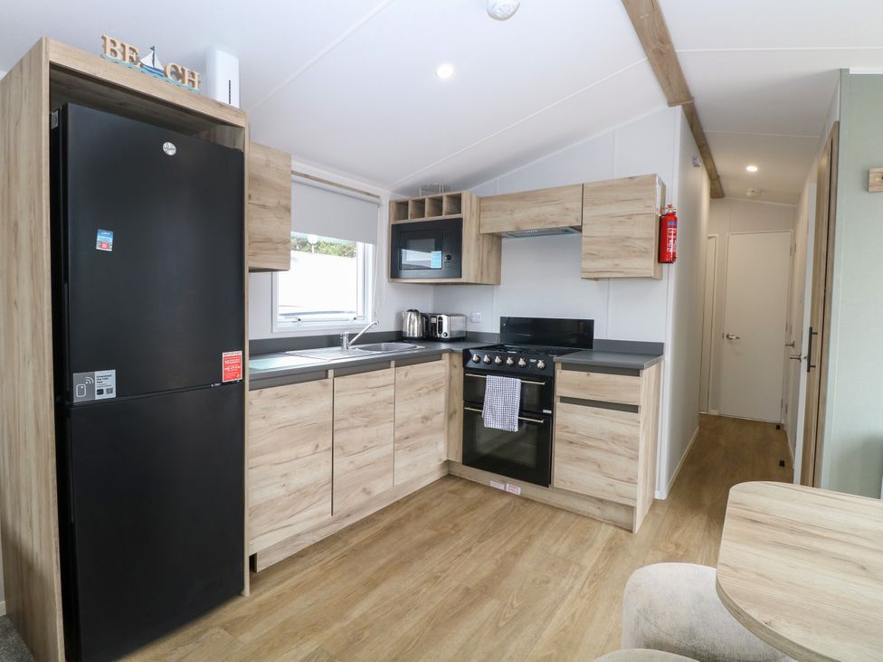 A kitchen with appliances and storage at Haven Seashore, Ellerton Willerby Xtra Great Yarmouth