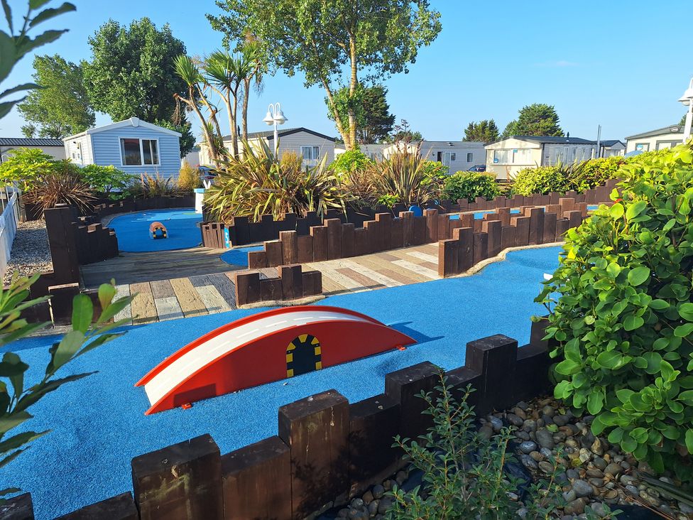 An outdoor play area with a small bridge and pathways at Haven Seashore, Ellerton Willerby Xtra, Great Yarmouth