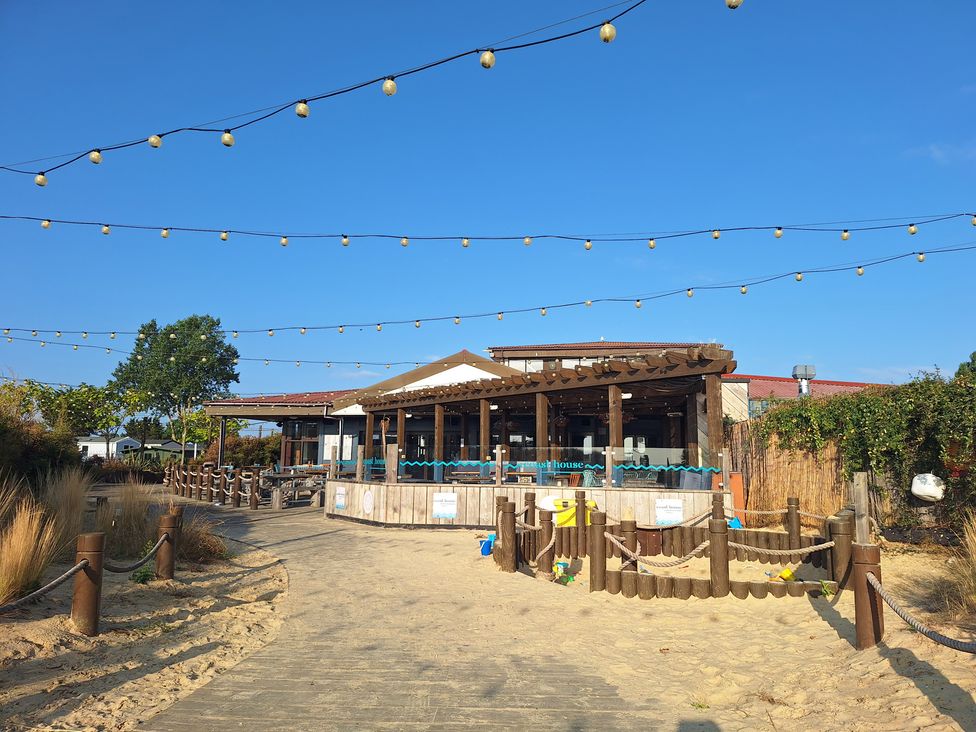 An outdoor seating area with a bar and plants at Haven Seashore, Ellerton Willerby Xtra, Great Yarmouth