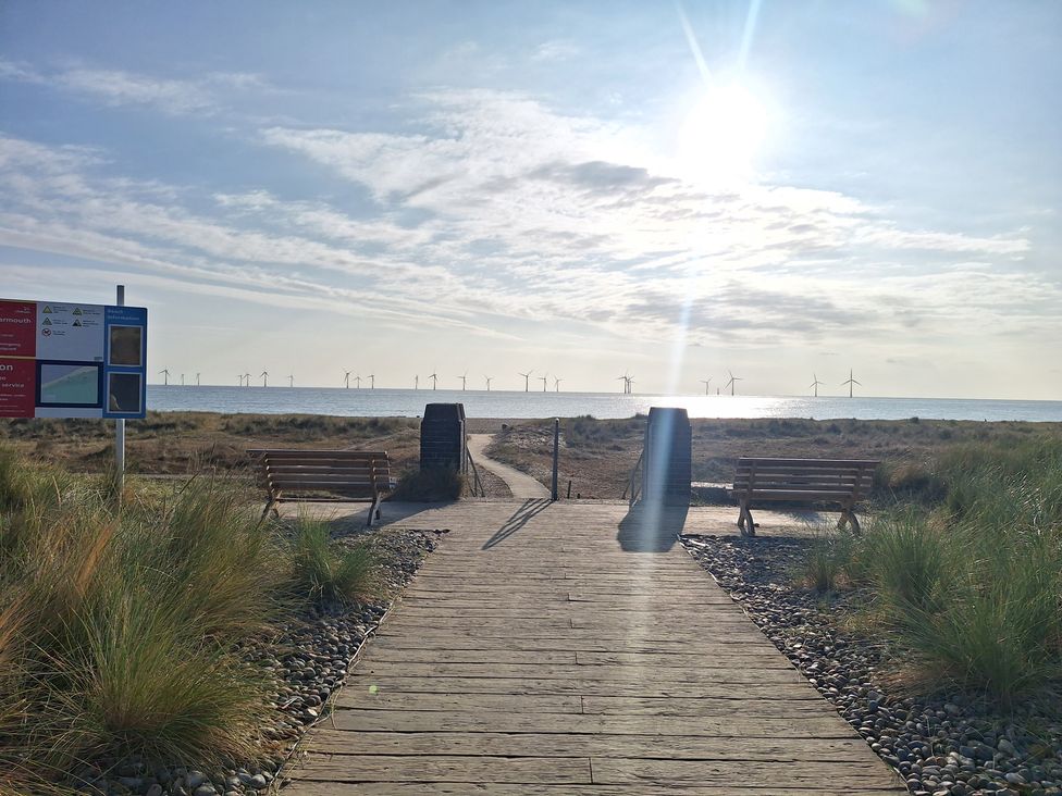 A pathway leading to the beach with benches and a signboard at Haven Seashore, Ellerton Willerby Xtra, Great Yarmouth