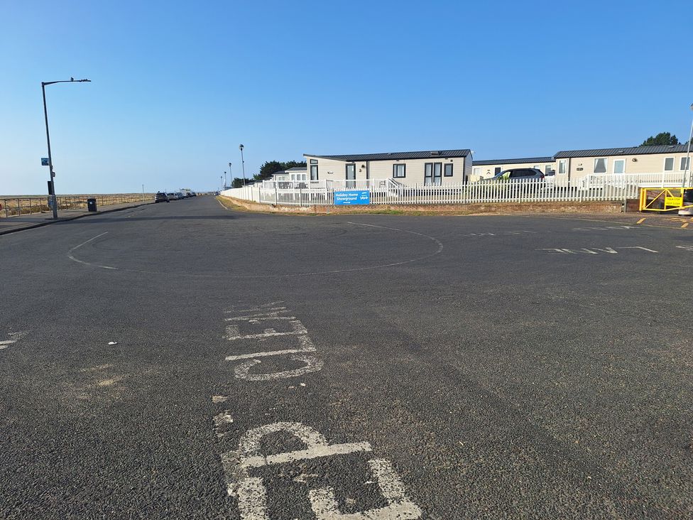 A view of a road with caravans and a fence at Haven Seashore, Great Yarmouth