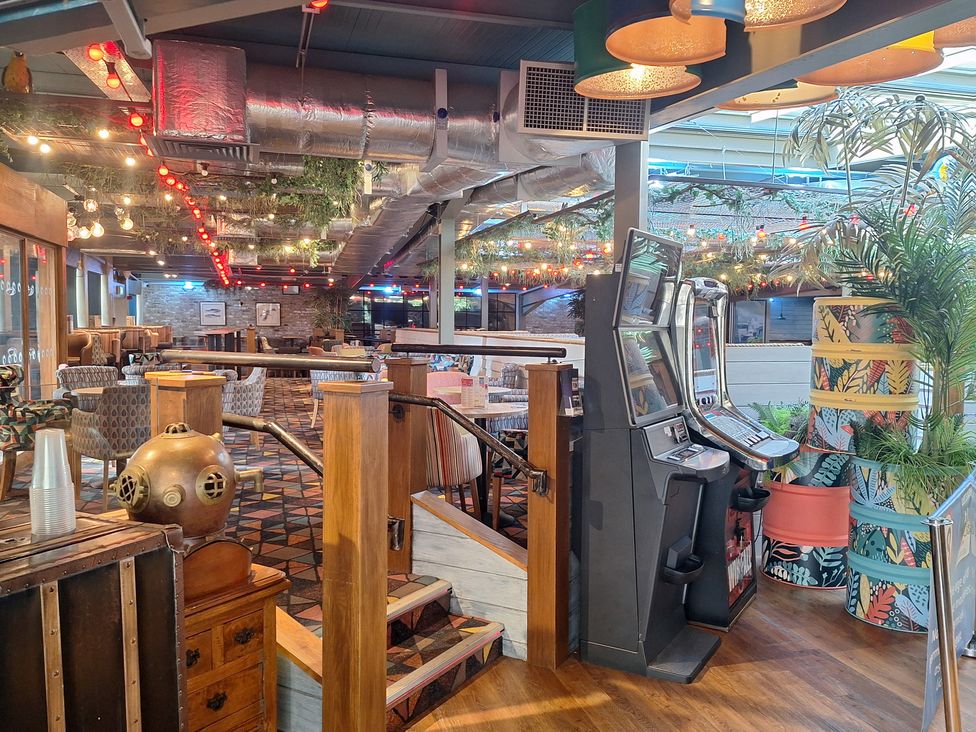 A dining room with slot machines and tables at Haven Seashore, Ellerton Willerby Xtra, Great Yarmouth