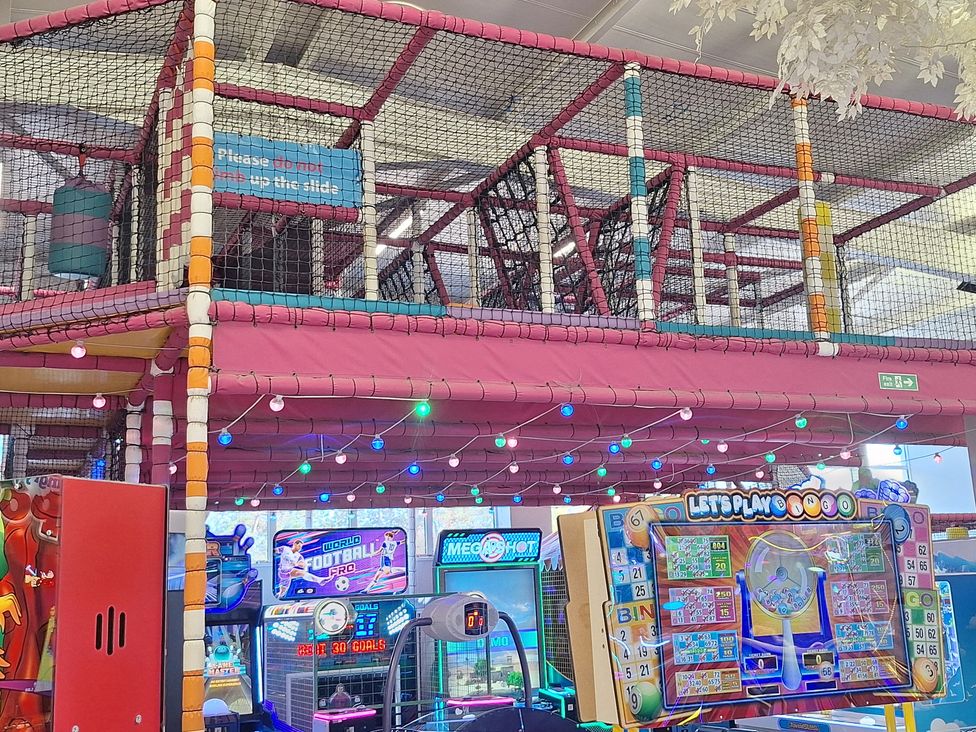 A play area with a climbing structure and arcade games at Haven Seashore, Ellerton Willerby Xtra in Great Yarmouth