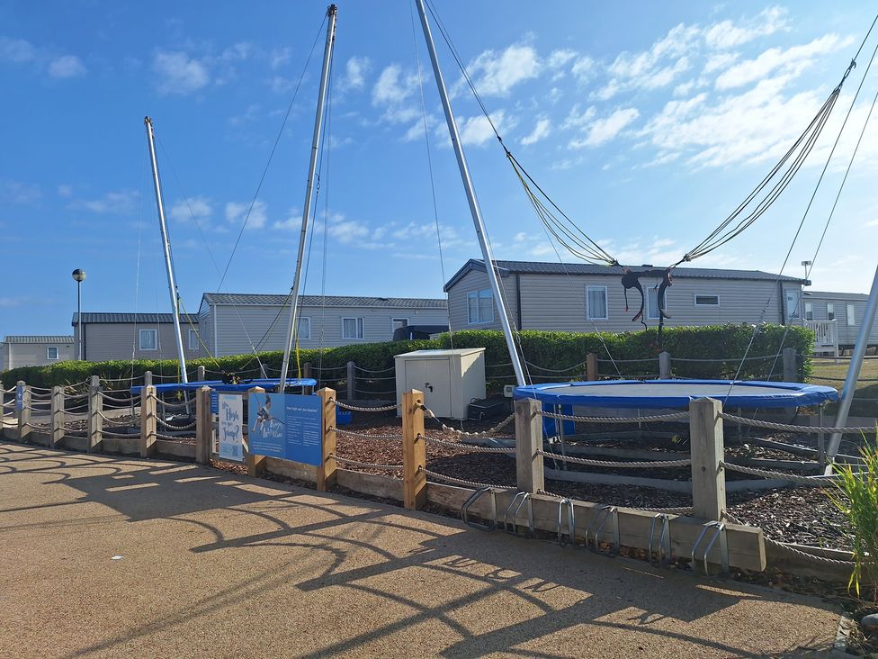 An outdoor area with a trampoline and caravans at Haven Seashore, Great Yarmouth