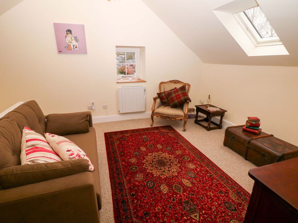 A living room with a sofa and armchair at Laneside Barn in Calver