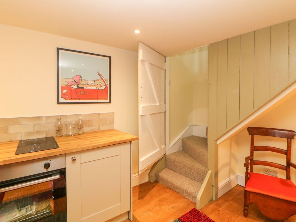 A kitchen with a wooden countertop and staircase at Laneside Barn in Calver