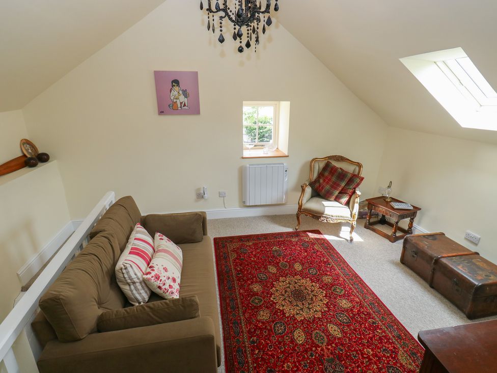 A snug with a sofa and an armchair at Laneside Barn in Calver