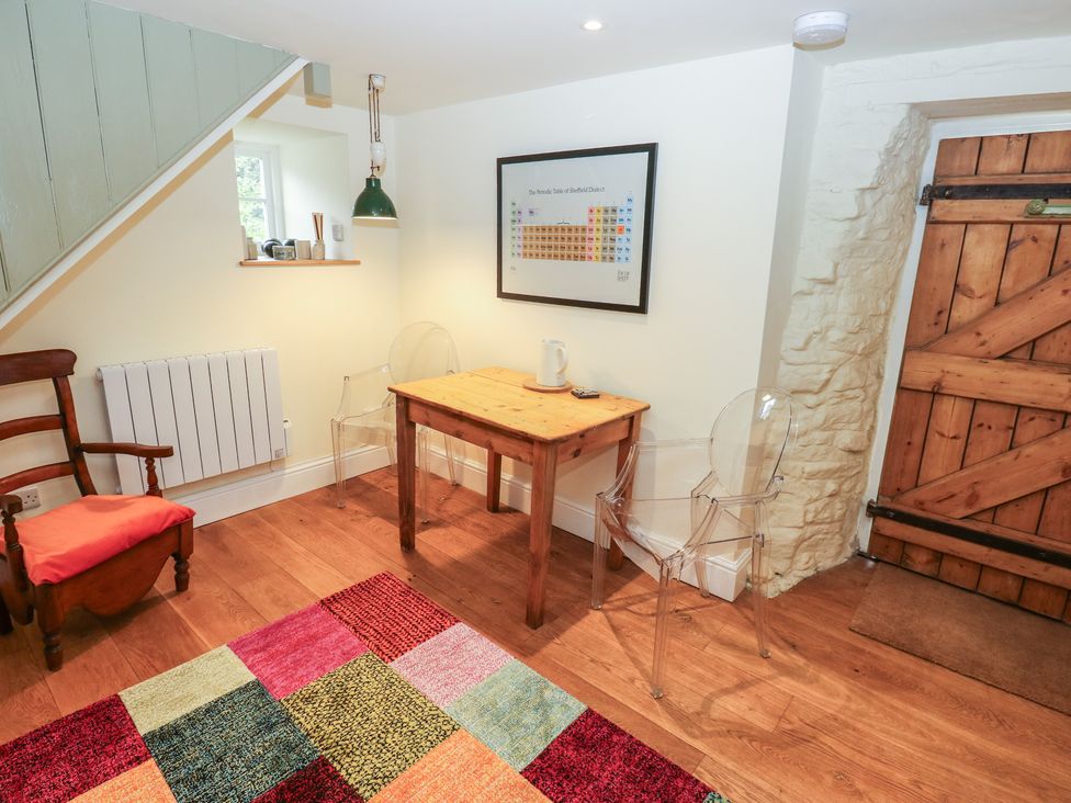 A dining area with a table and chairs at Laneside Barn Calver