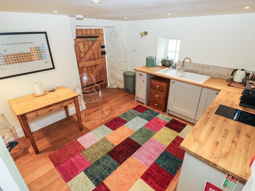 A kitchen with a table and chair at Laneside Barn Calver