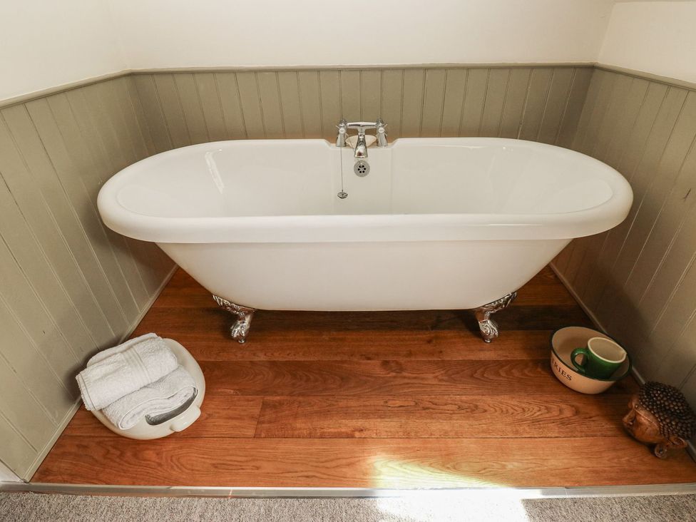 A bathtub with a towel and bowls at Laneside Barn Calver