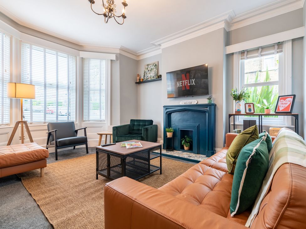 A living room with a sofa, chair, television, and coffee table at 59 Garfield Road in Scarborough