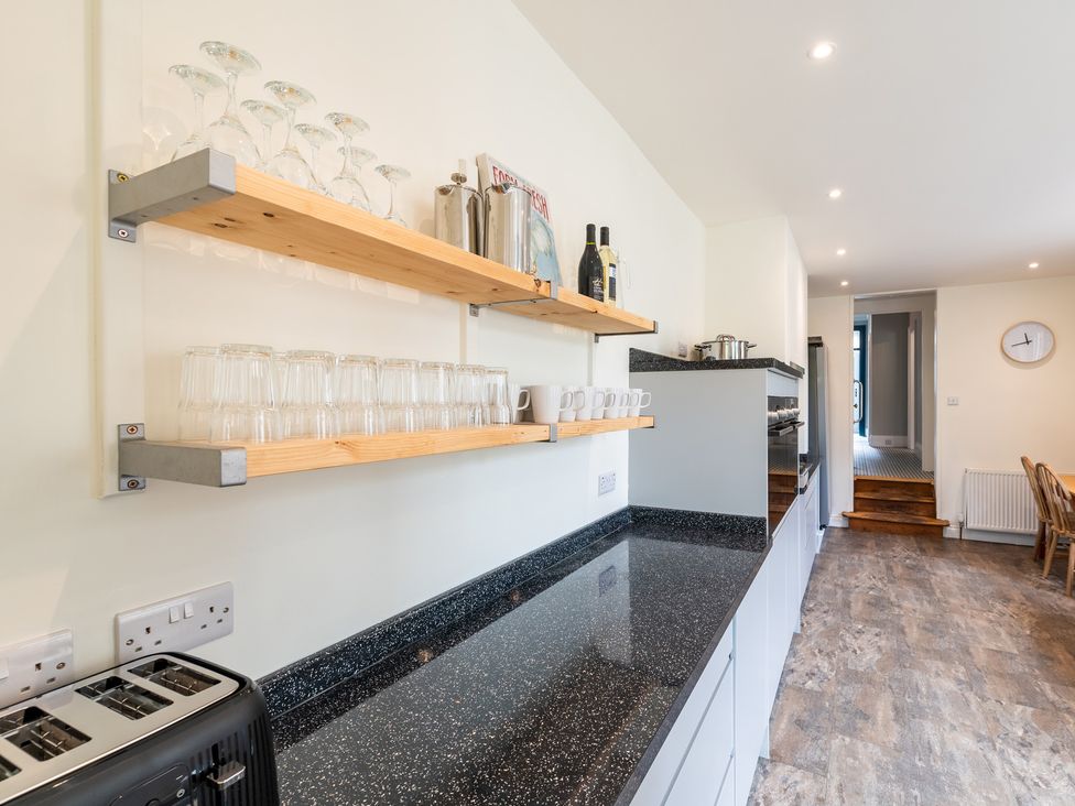 A kitchen with shelves holding glasses and mugs at 59 Garfield Road, Scarborough