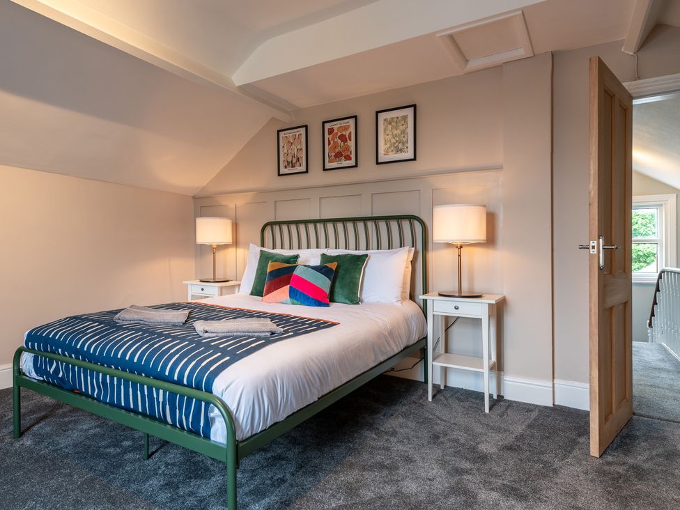 A bedroom with a bed, side tables, and wall art at 59 Garfield Road in Scarborough