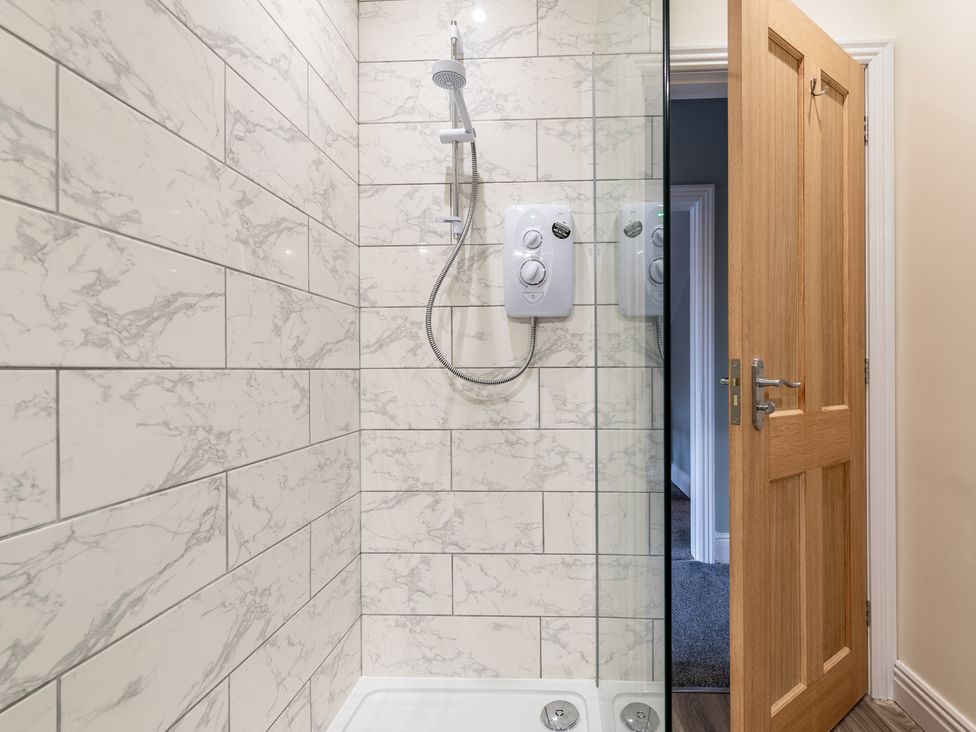 A shower with a glass screen and tiled walls at 59 Garfield Road in Scarborough