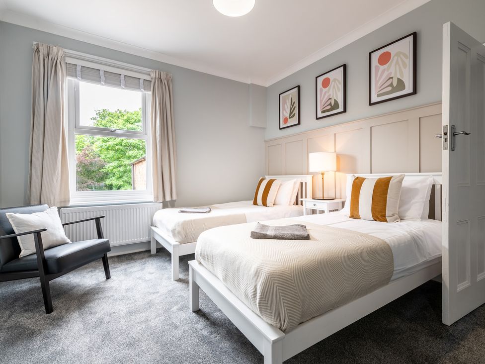A bedroom with two beds and a chair at 59 Garfield Road in Scarborough
