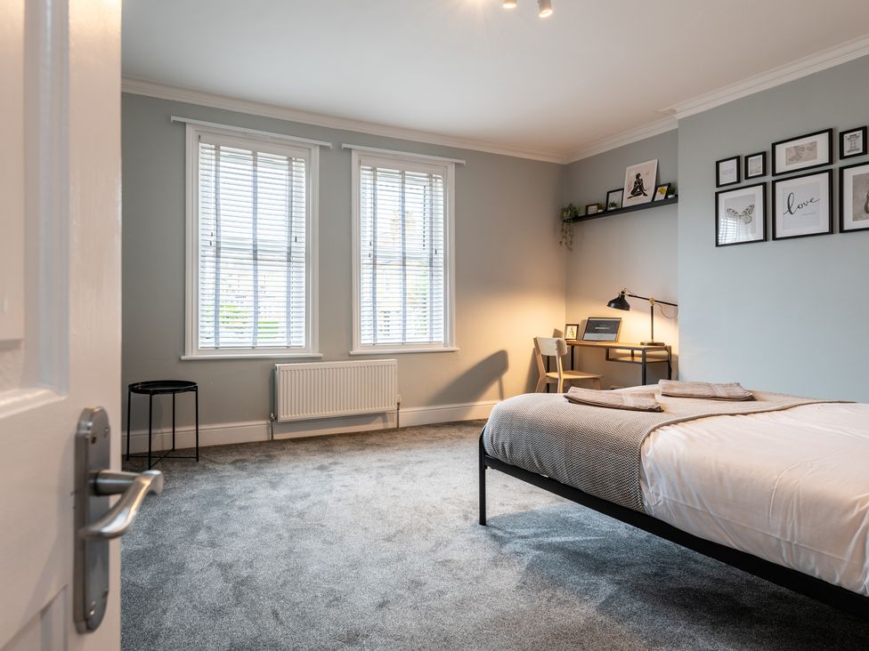 A bedroom with a bed, desk, and windows at 59 Garfield Road in Scarborough
