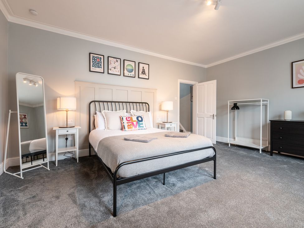 A bedroom with a bed, bedside table, lamp and wardrobe at 59 Garfield Road Scarborough