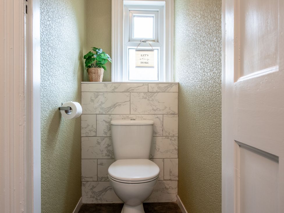 A bathroom with a toilet and a window at 59 Garfield Road in Scarborough