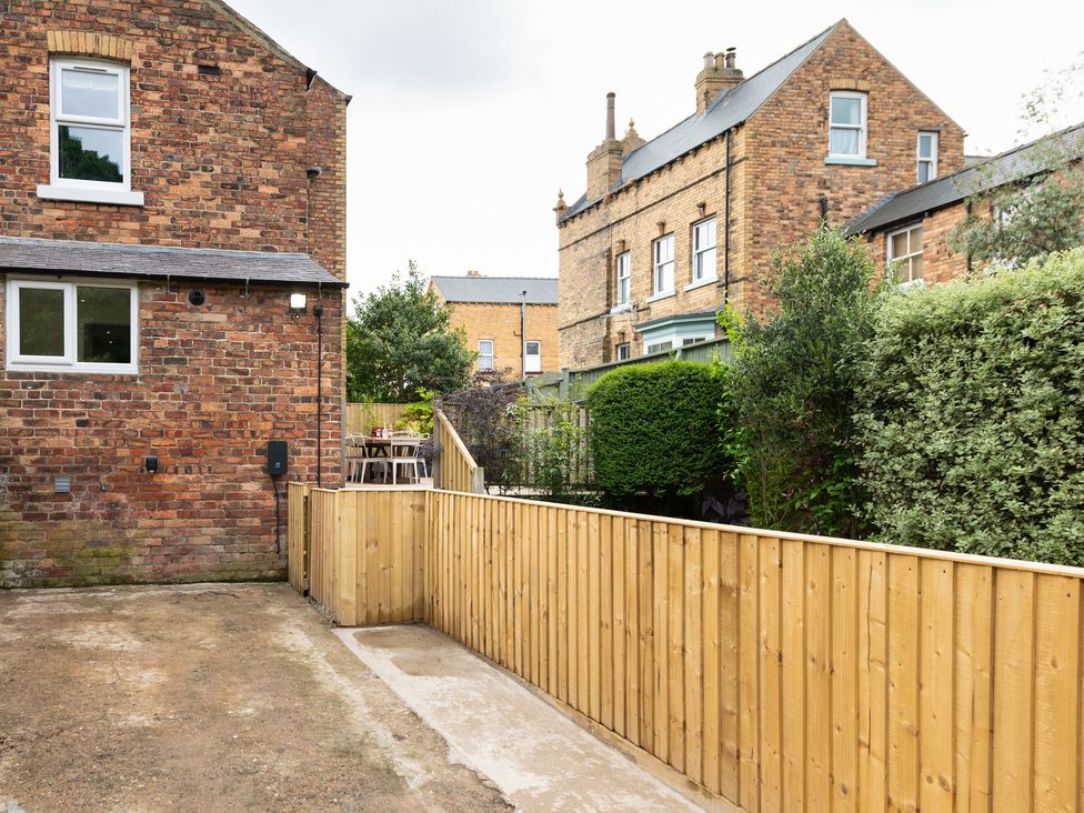 A garden with a wooden fence and seating area at 59 Garfield Road Scarborough