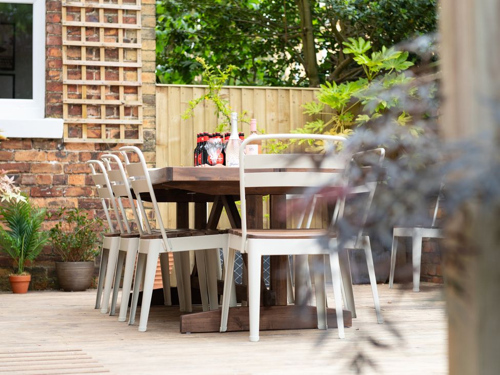 An outdoor dining area with a wooden table and chairs at 59 Garfield Road, Scarborough