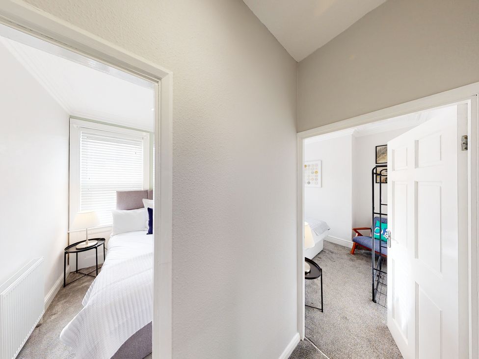 A view into two bedrooms with beds and furniture at 44 Norwood Street Scarborough
