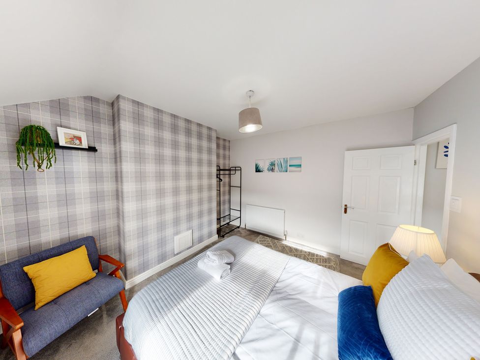 A bedroom with a bed a sofa and artwork at 44 Norwood Street Scarborough