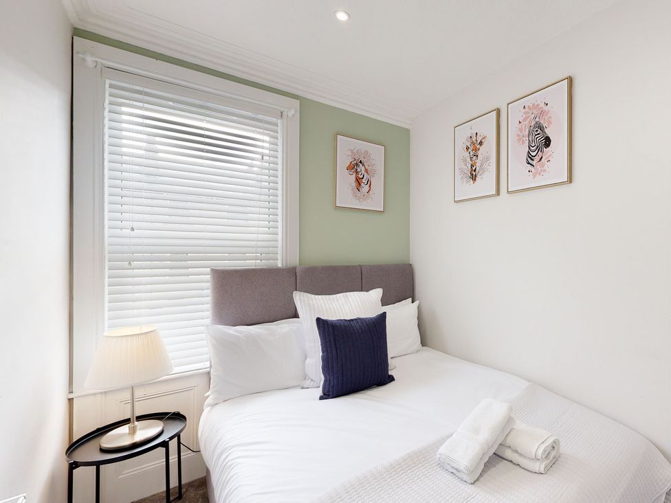 A bedroom with a bed and wall art at 44 Norwood Street, Scarborough