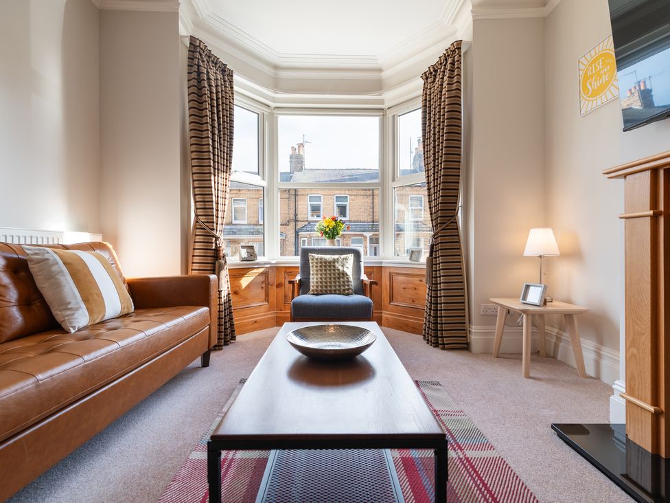 A living room with a sofa, table, and lamp at 18 Mayville Avenue, Scarborough