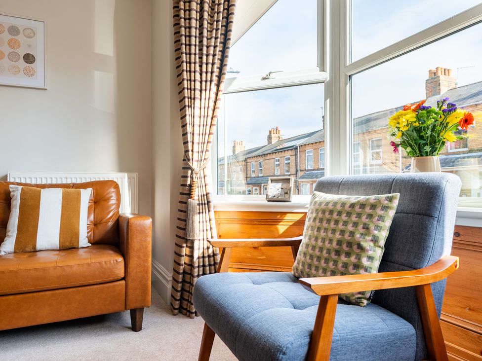 A living room with an armchair and a sofa at 18 Mayville Avenue Scarborough